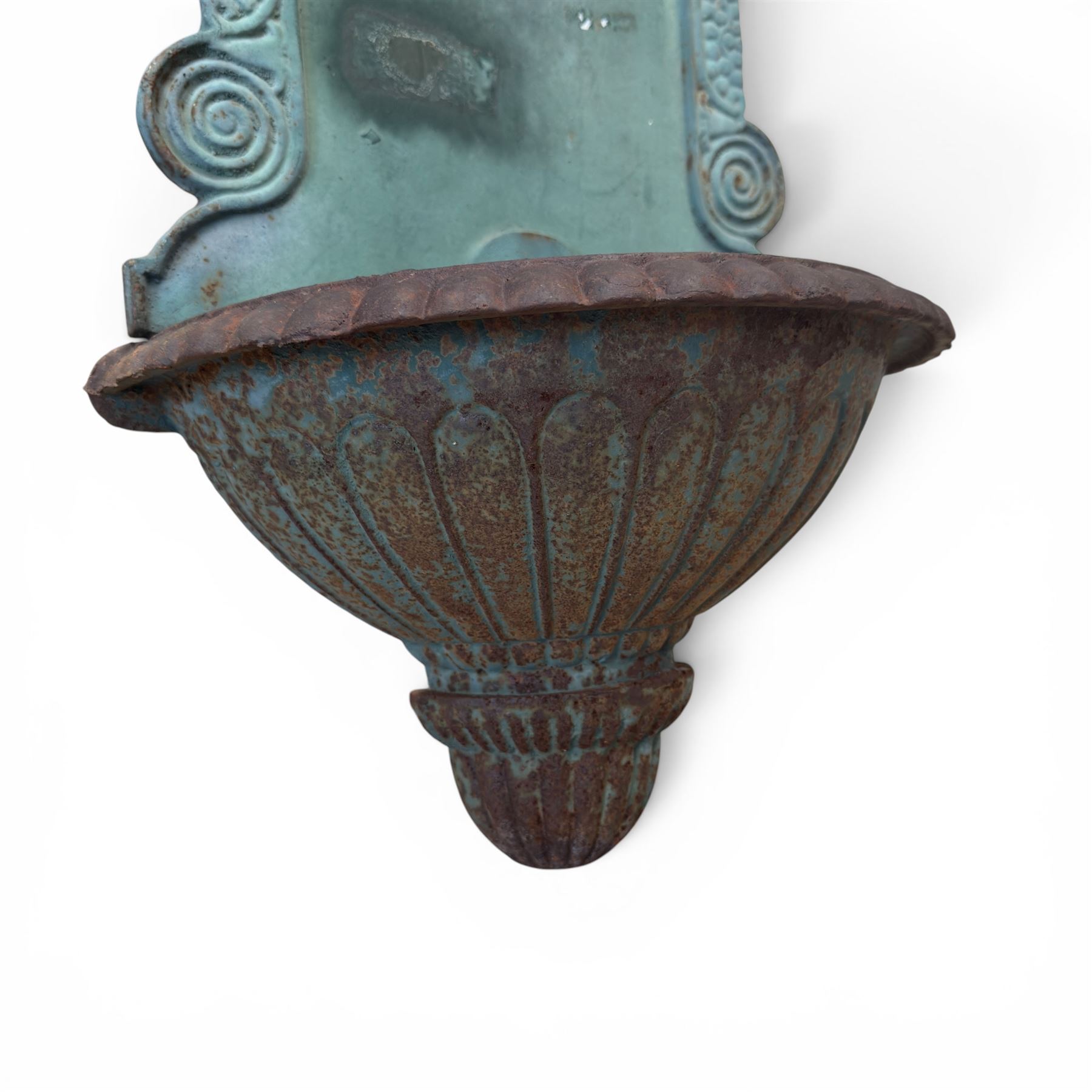 Antique cast iron wall fountain, cartouche cresting rail over a lion mask spout, with scroll and floral decoration over a scalloped basin, in rustic turquoise painted finish with rusted patina