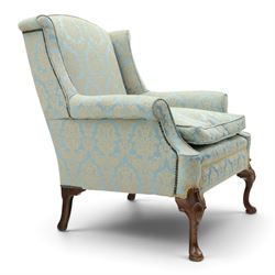 Georgian design carved mahogany framed wingback armchair, high wingback over sprung seat and loose cushion with rolled arms, upholstered in cyan ground gilt foliate damask fabric, on shell-carved cabriole supports with pad feet
