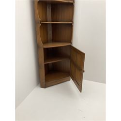 Ercol style elm corner cupboard, fitted with two shelves above single panelled cupboard door enclosing single shelf, stile supports 