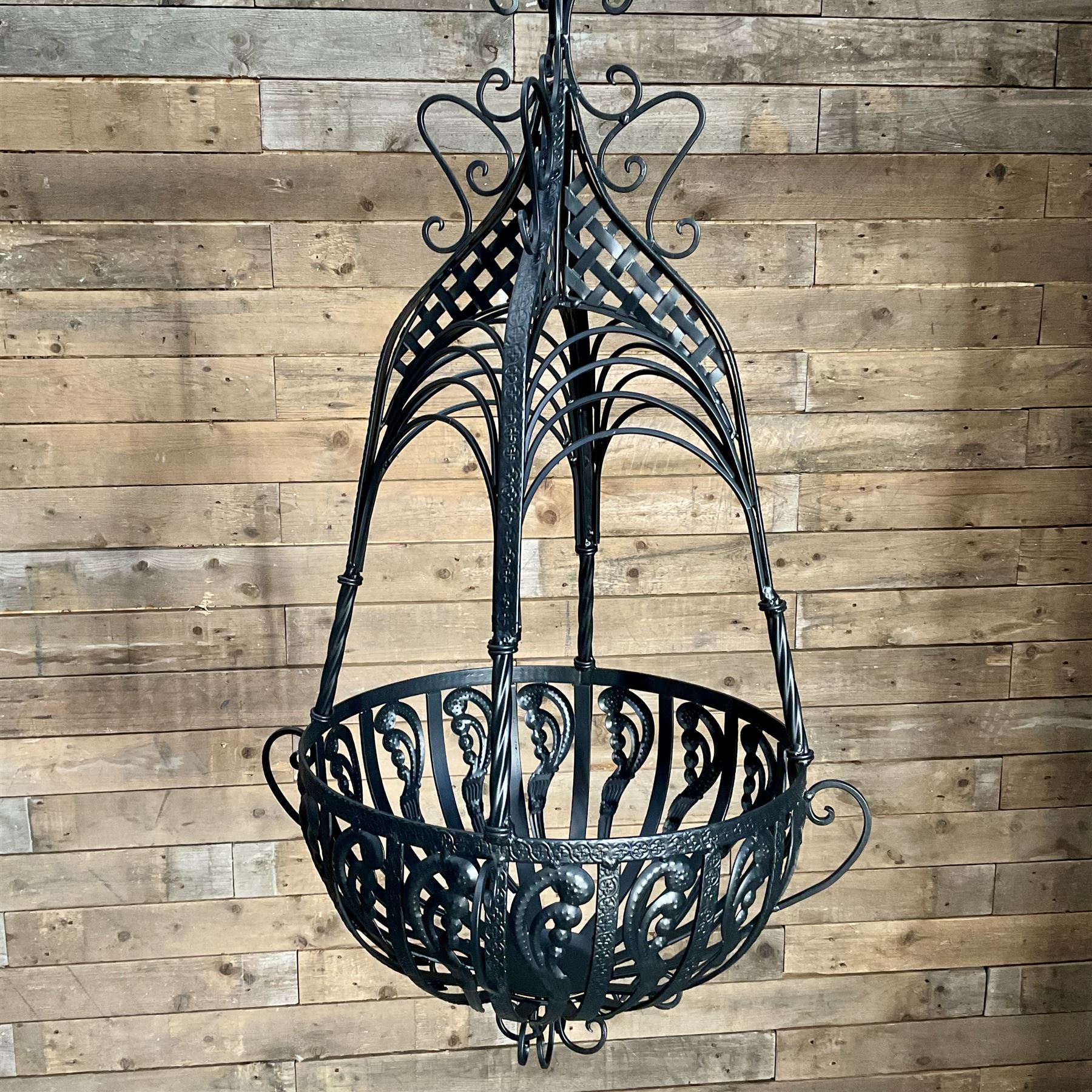 Pair of black finish wrought metal hanging baskets, with brackets