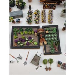 1:12 scale dolls house allotment and garden accessories, including wooden shed on a stone effect base, two vegetable patches, terracotta plant pots with flowers and foliage, stone effect plant pots, other planters, loose sunflowers, scarecrow, rabbit hutch, garden tools, fencing panels, etc 
