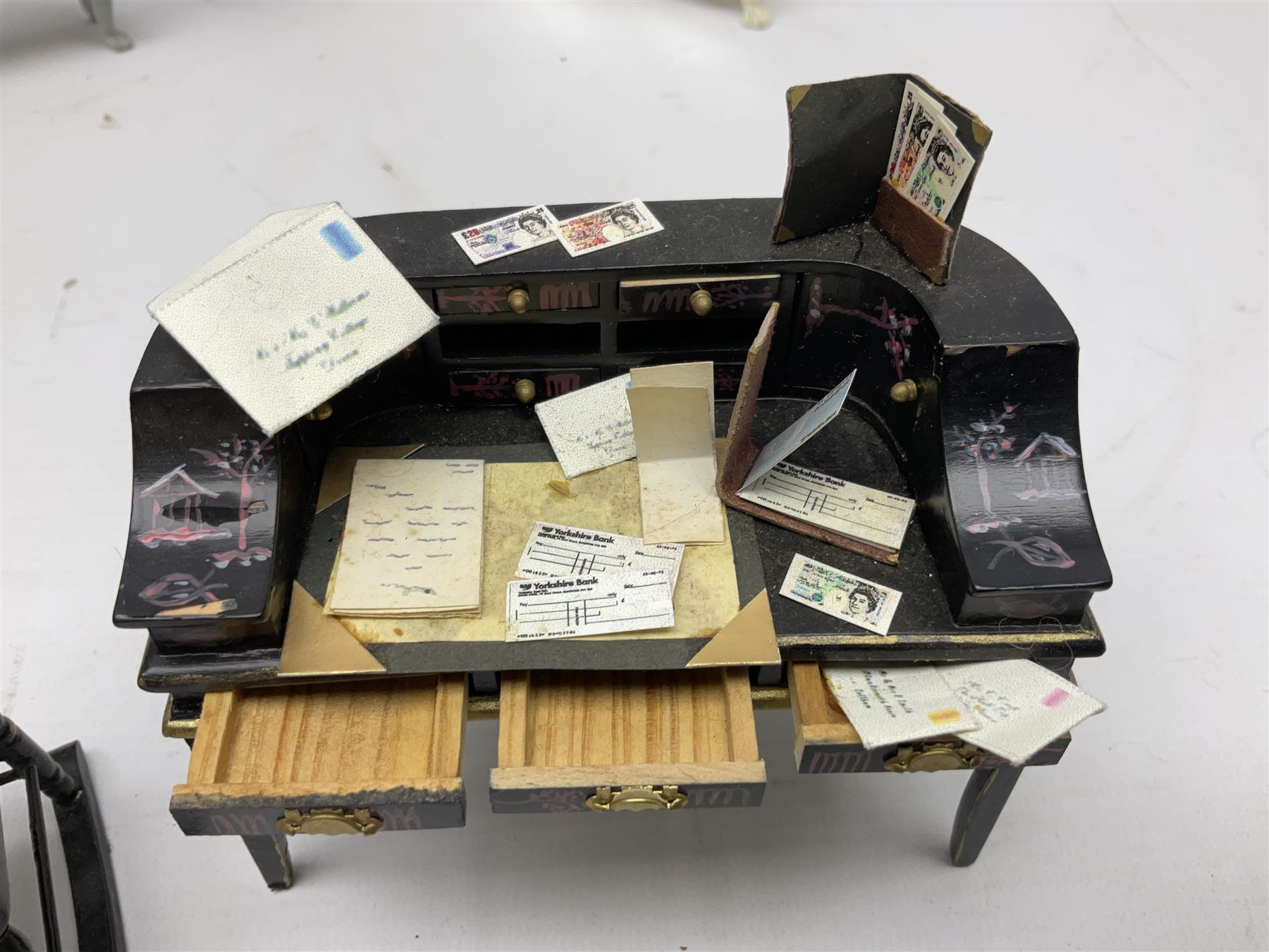Collection of miniature dolls house furniture, to include five drawer chest painted with blossom, cream and gilt double door mirrored wardrobe, four piece lacquered style desk set, three piece suite, writing desk, wash stand, Knoll style sofa etc (14)