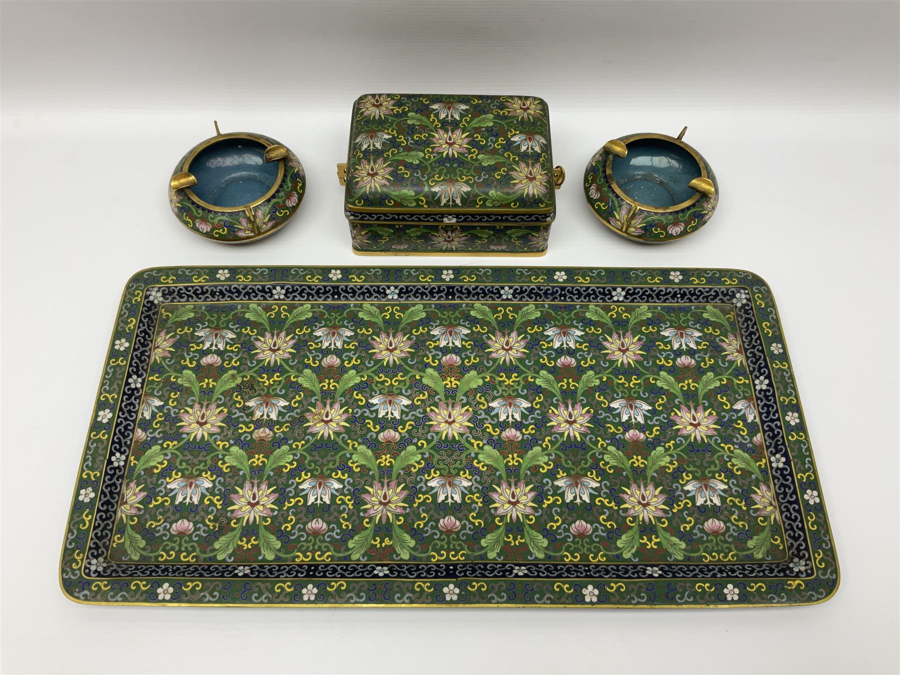 20th century Chinese cloisonne enamel smoking set, comprising two ashtrays, box and tray, with floral and foliate scrolling on green ground