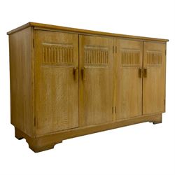 Early to mid-20th century limed oak sideboard, four doors carved with arcades enclosing shelves and two drawers, on bracket feet