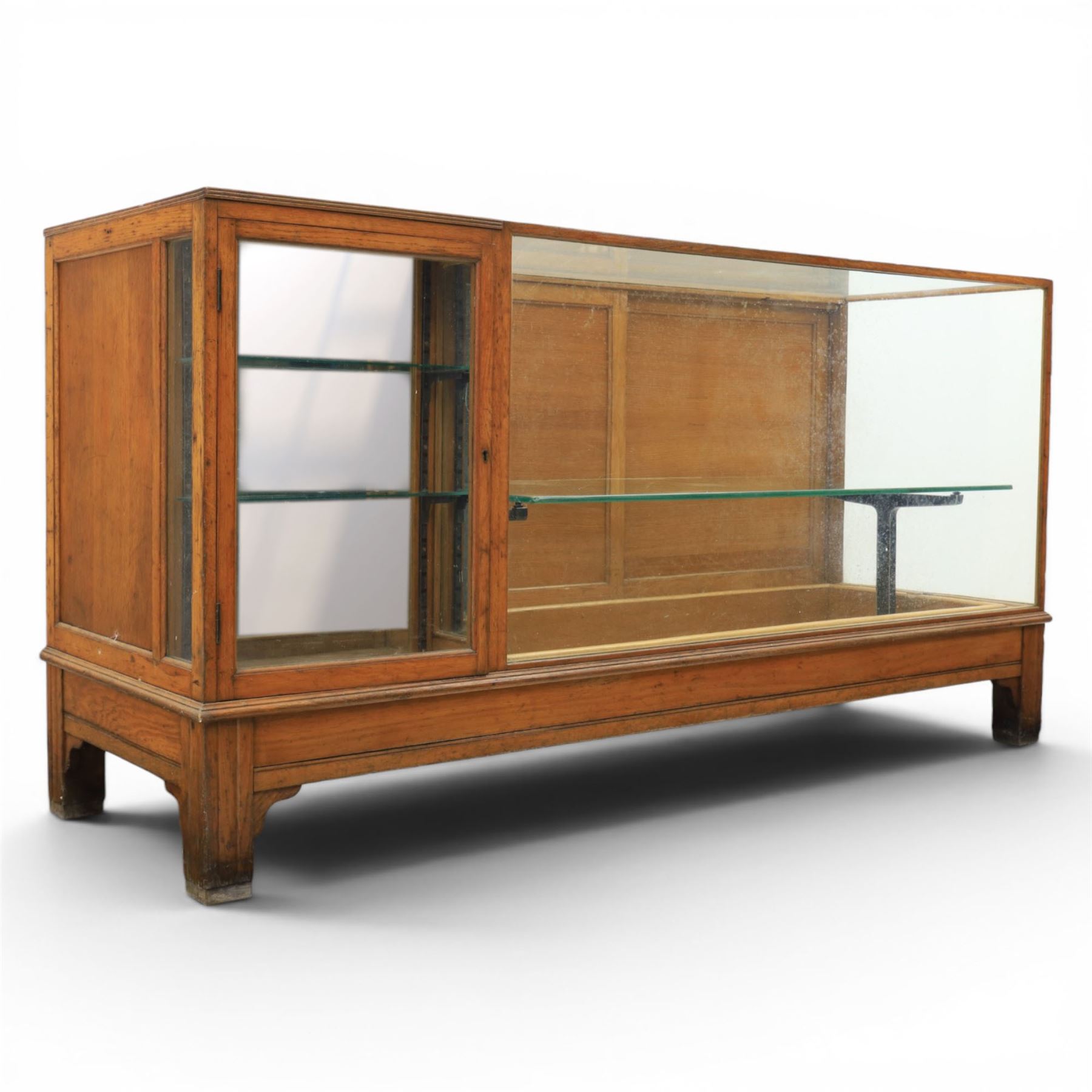 Early 20th century oak framed and glazed haberdashery shop counter with sliding doors and cupboards