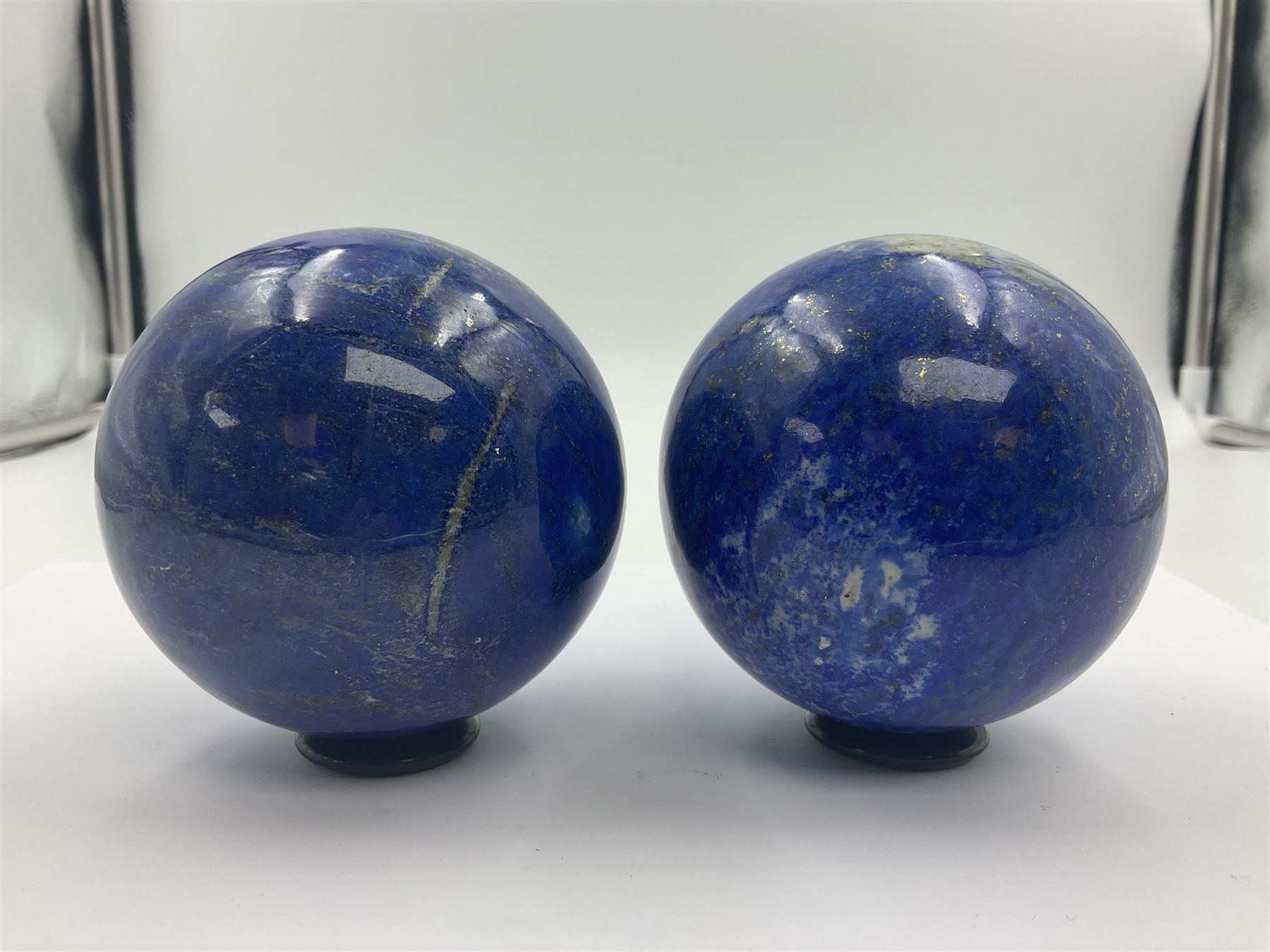 Pair of Lapis lazuli spheres, upon a carved stone stands, D8cm