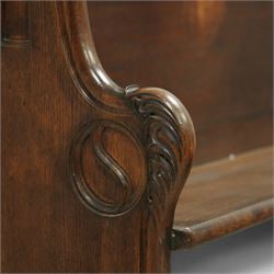 Late 19th century Gothic revival oak church pew, with high backrest framed by carved stylised cross panels and crown-topped finials, shaped end panels with scroll detailing, on block end supports and central stretcher, with later padded seat cushion