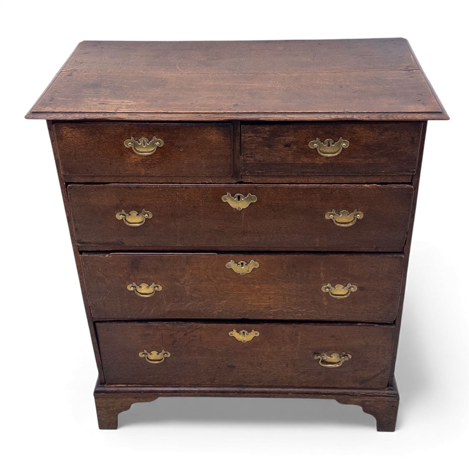 18th century oak chest, the rectangular top above an arrangement of two short over three long drawers fitted with brass batwing handles and escutcheons, raised upon shaped bracket feet
