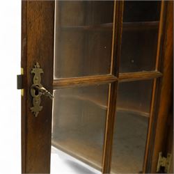 Early 20th century oak wall-mounted corner cabinet, moulded cornice above a single glazed door with six-panel astragal glazing, fitted interior with two shaped shelves