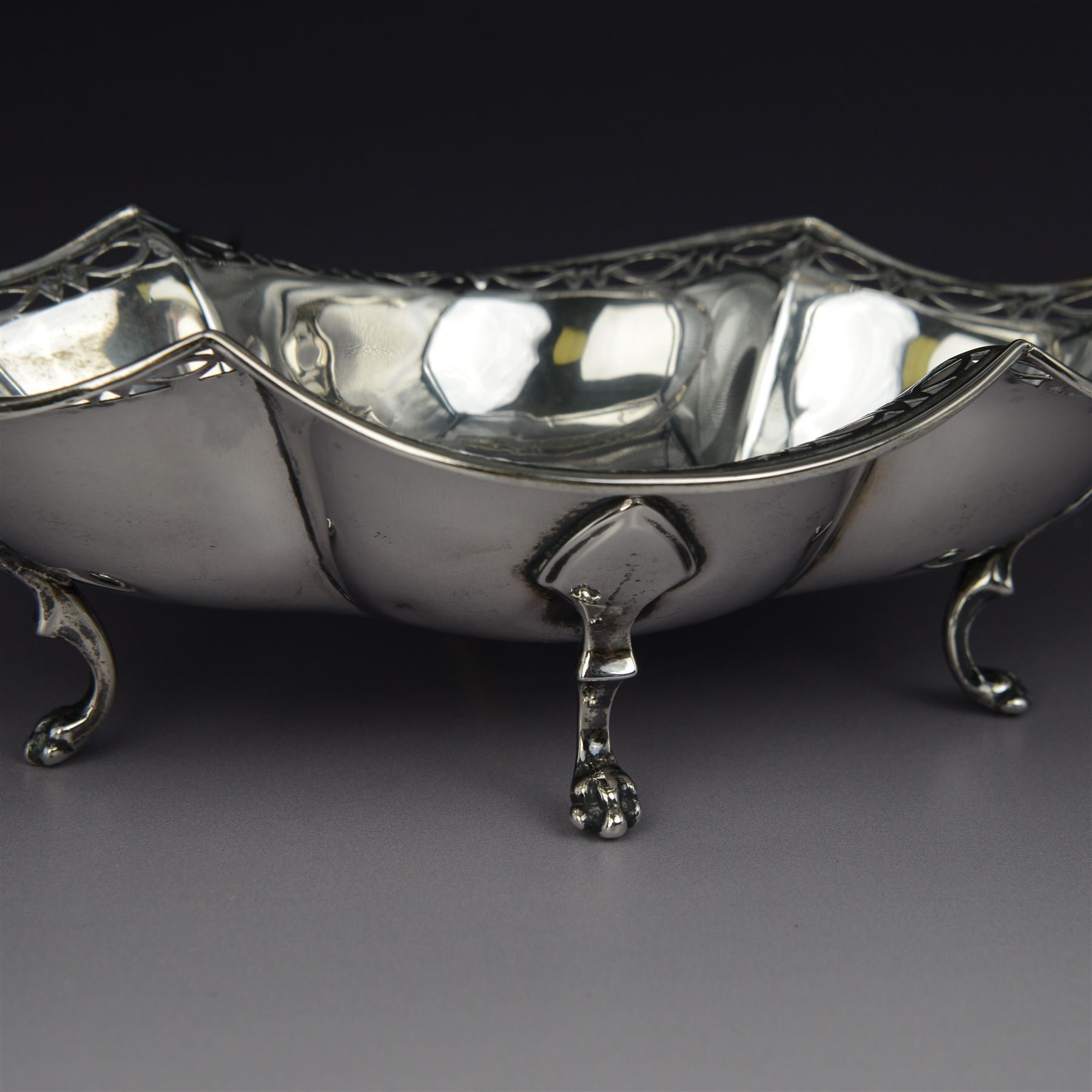 1920s silver basket, of navette form with pierced rim and lobed bowl, with fined pierced handle and upon four paw feet, hallmarked Sibray, Hall & Co Ltd, Sheffield 1923, including handle H18.5cm
