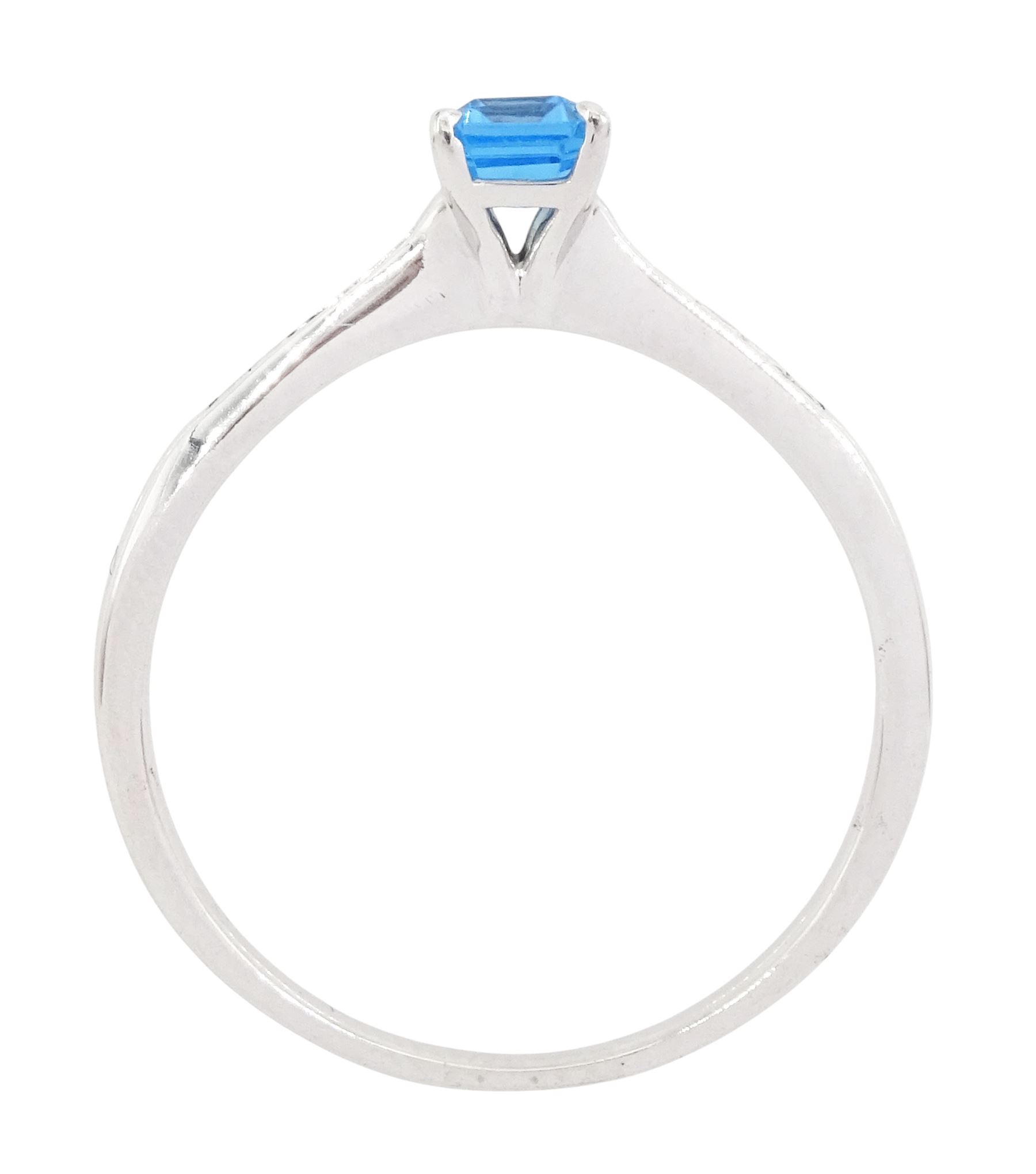 18ct white gold blue topaz and diamond ring, the single emerald cut topaz of approx 0.65 carat, each shoulder set with five, channel set princess cut diamonds
