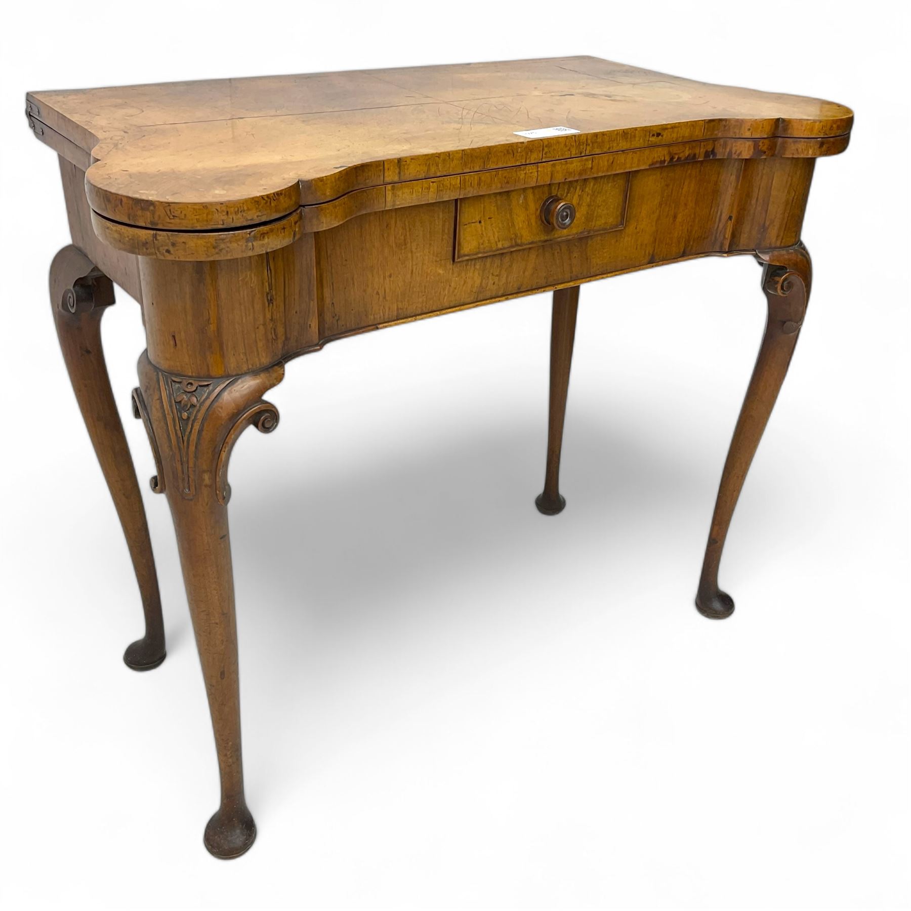 Georgian walnut fold-over card table, shaped rectangular top opening to reveal a baize-lined surface, supported by a concertina pull-out rear mechanism, frieze fitted with single drawer, raised on cabriole supports with foliate carvings terminating in pad feet