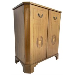 John More of Scarborough -  Edwardian Revival 'Canterbury Cabinet' inlaid mahogany cabinet, fitted with double cupboard decorated with urn motif inlays and banding, flanked by canted fluted uprights, on bracket feet