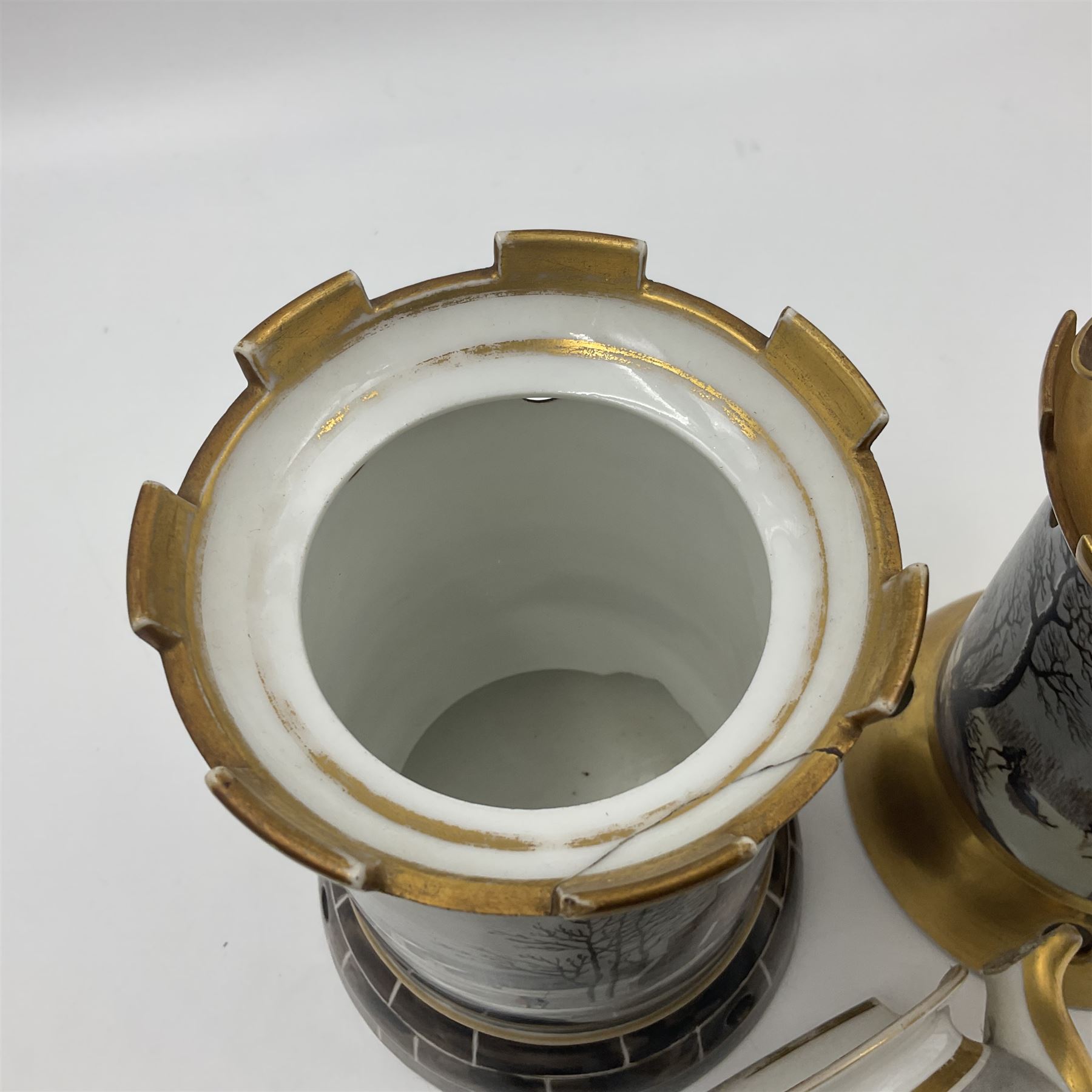 Two 19th century continental teapots and warmers, each teapot upon a cylindrical warming base in the form of a castle, hand printed with winter landscapes, largest H22cm 