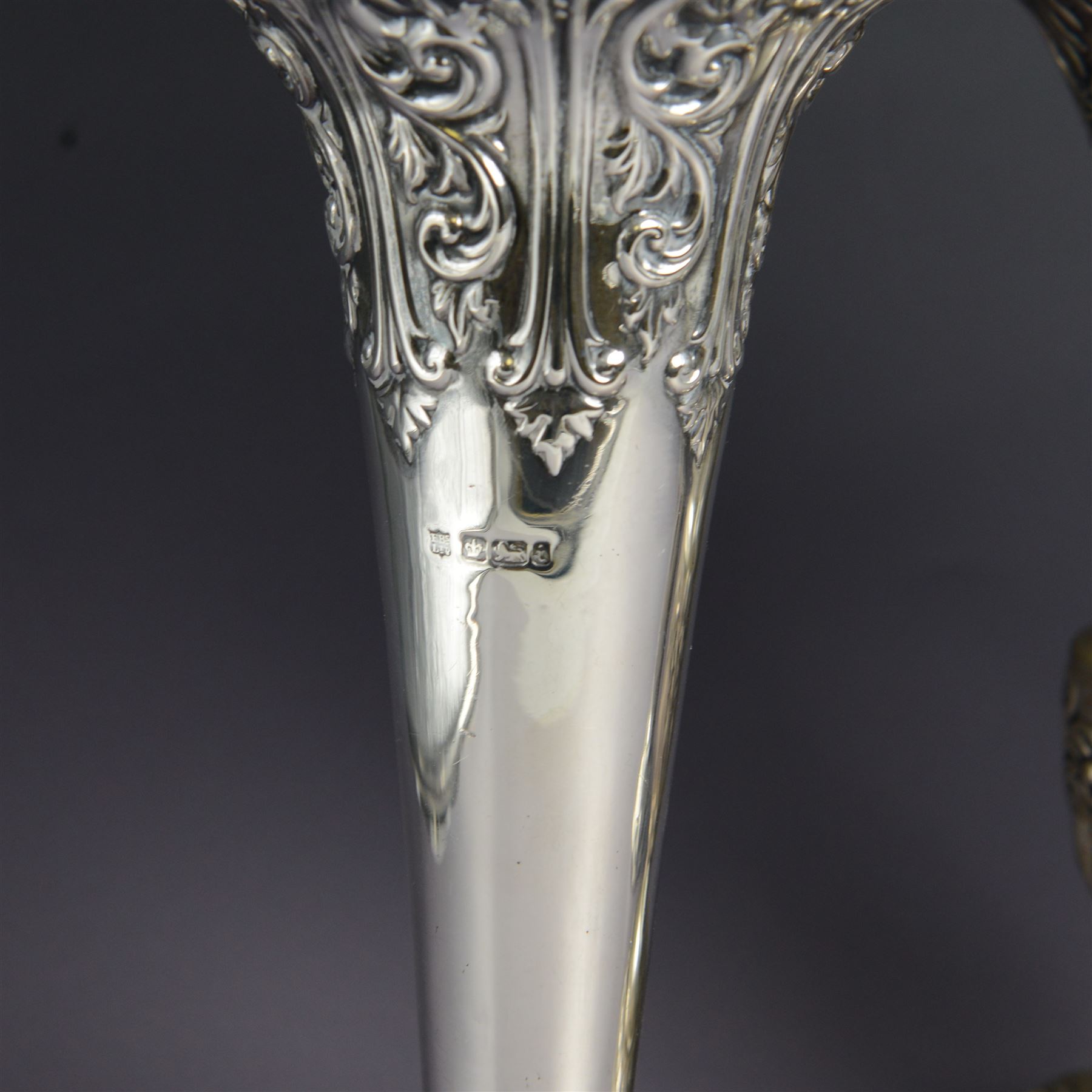 Three late 19th century/early 20th century silver vases, of trumpet form, all embossed with floral and foliate decoration, one example with weighted base, all hallmarked, tallest H18cm