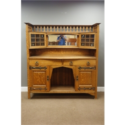  Arts & Crafts oak dresser, raised gallery back with centre bevelled mirror and canted display cabinets glazed with bullseye glass panes, two drawers and panelled cupboards, pierced heart motifs, beaten metal strap hinges and moulded handles, possibly 'Shapland & Petter of Barnstaple', W160cm, H167cm, D59cm  