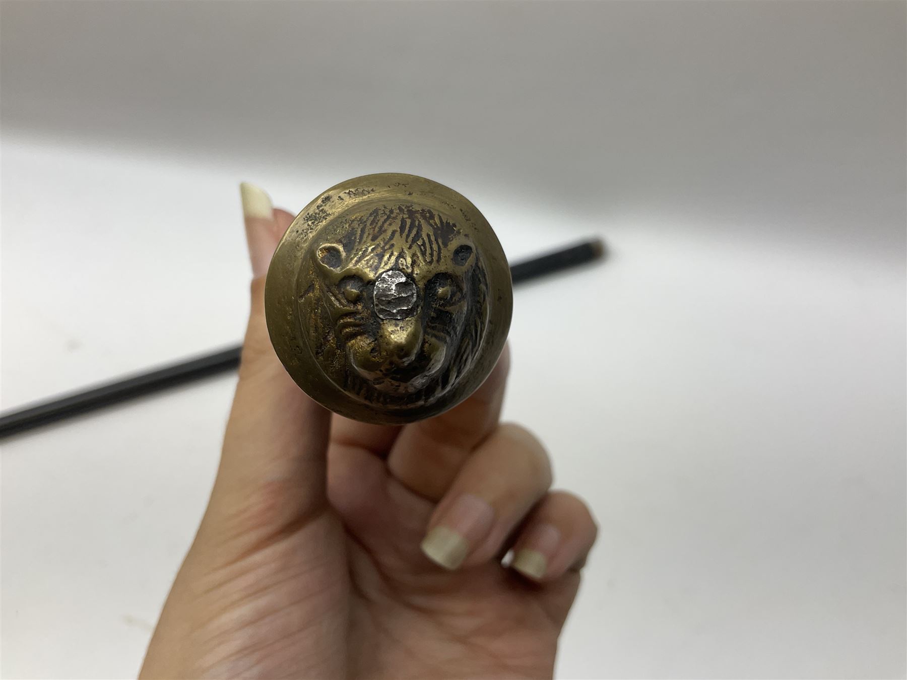 
Late 19th/early 20th century Anglo Indian ebony and bone sword stick with 62cm steel blade, brass locking ferrule and lion mask pommel L92 cm.