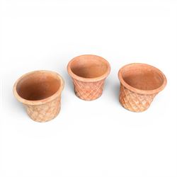 Three terracotta planters with lattice relief and rolled rim