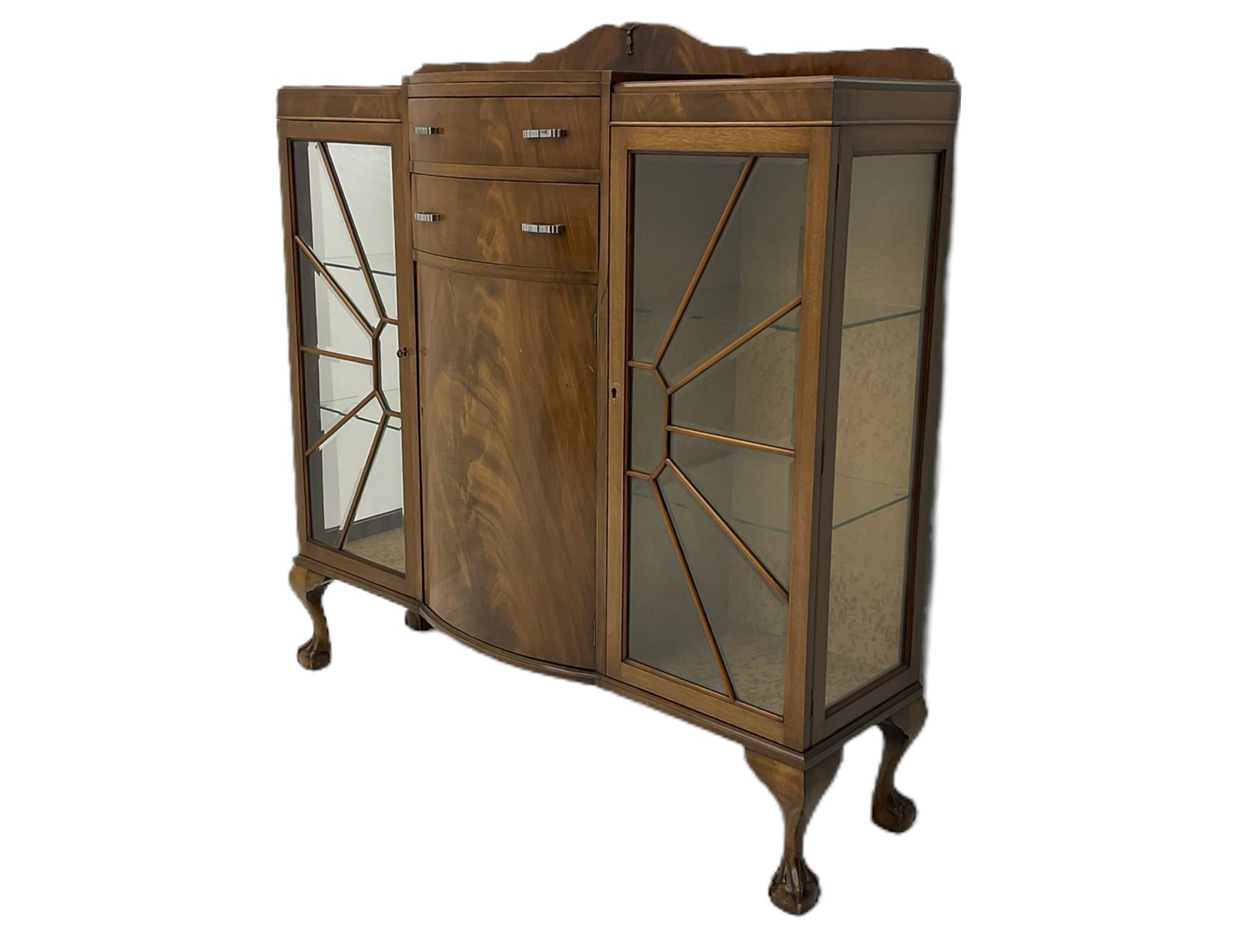 Mid-20th century Art Deco style walnut display cabinet, two central drawers over cupboard flanked by two bevel glazed display cabinets with sunburst astragal glazing, on ball and claw cabriole feet