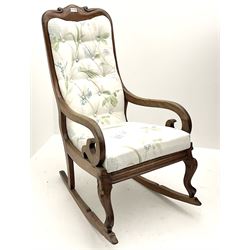 Victorian mahogany framed rocking armchair, scroll carved detail, upholstered in floral patterned fabric, raised on carved cabriole supports on rockers 