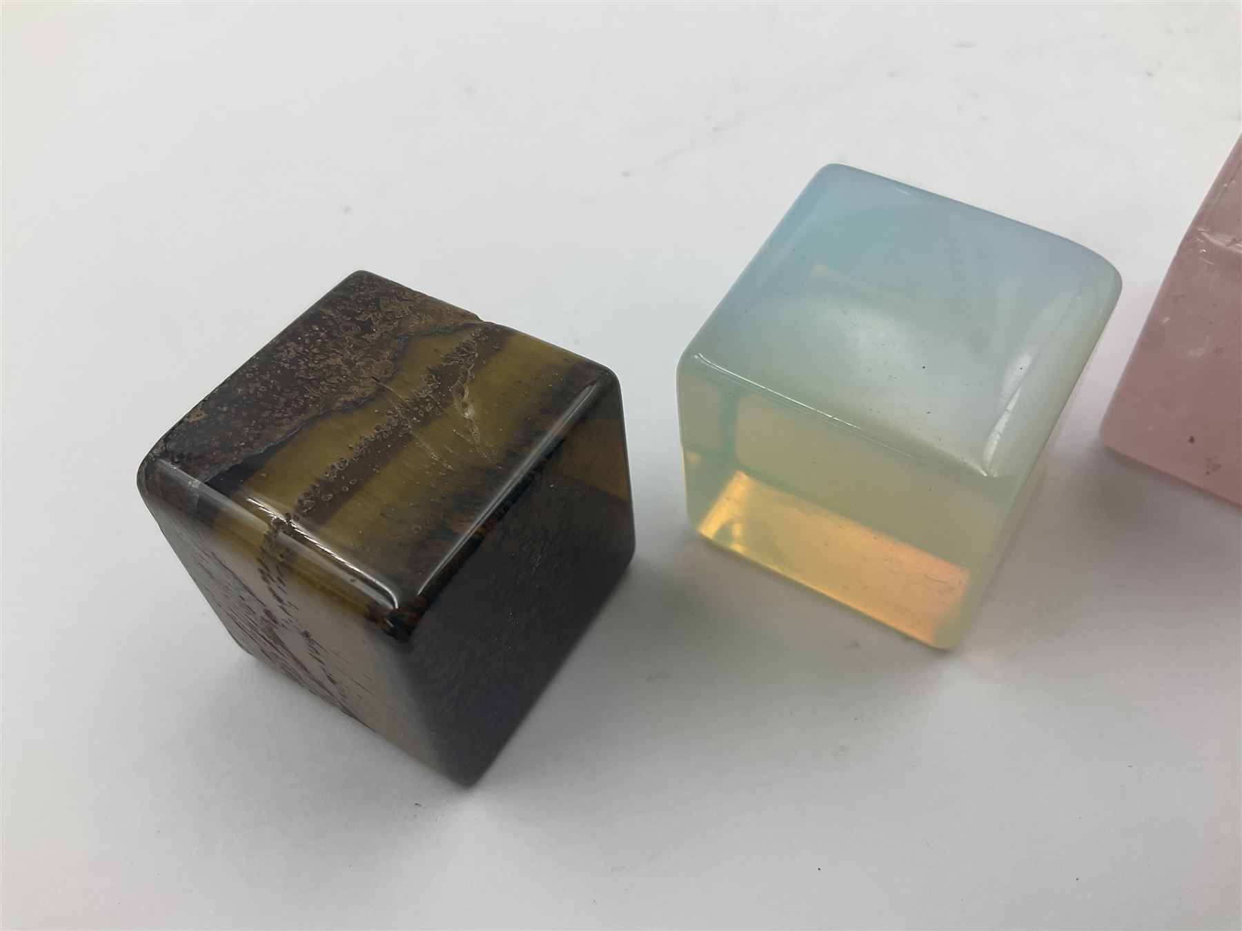 Ten cube mineral specimens, each cut and polished to highlight natural formations, including tiger eye, green aventurine, rose quartz, opalite, amethyst etc, H3cm 