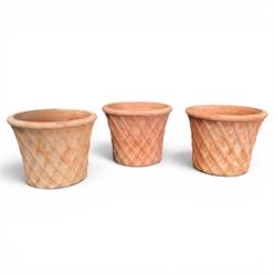 Three terracotta planters with lattice relief and rolled rim