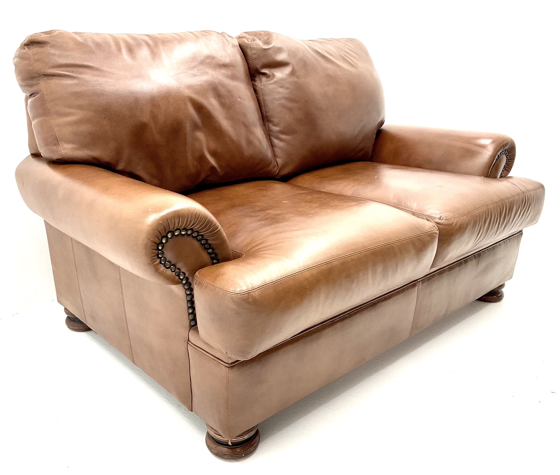 Three seat studded tan leather sofa, scrolling arms, turned supports (W190cm) with matching two seat (W155cm) armchair (W100cm) and footstool 