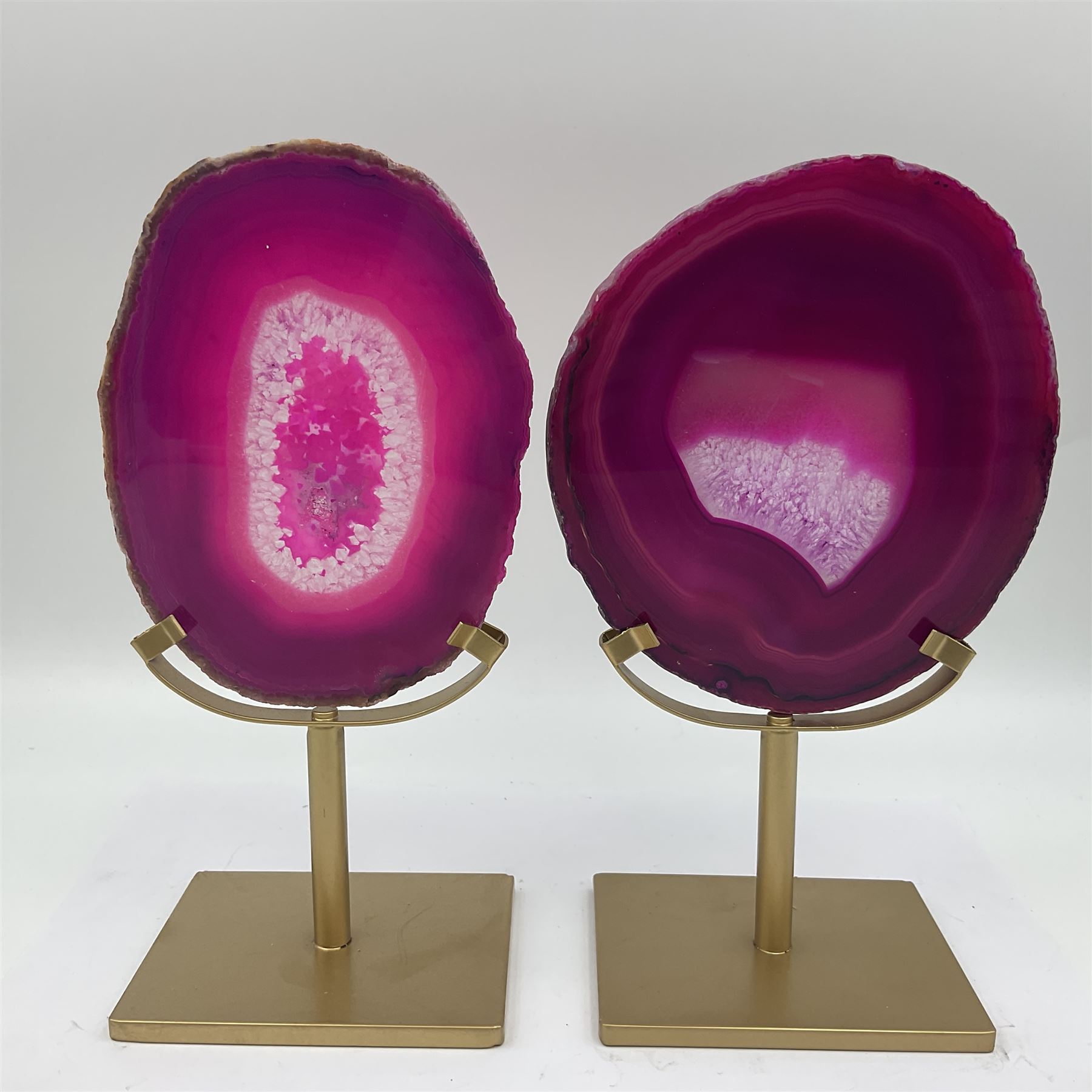 Pair of pink agate slices, polished with rough edges raised upon gilt metal stands, H20cm