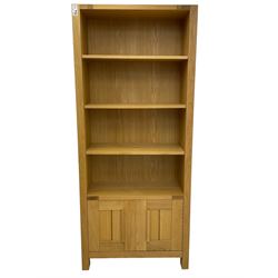 Light oak open bookcase, three adjustable shelves over double cupboard