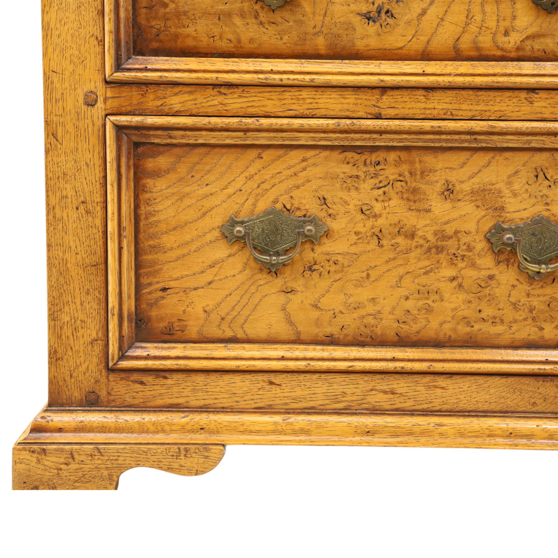 Small 20th century burr oak chest, the figured top over three graduated drawers with moulded fronts and pierced brass handles, on shaped feet