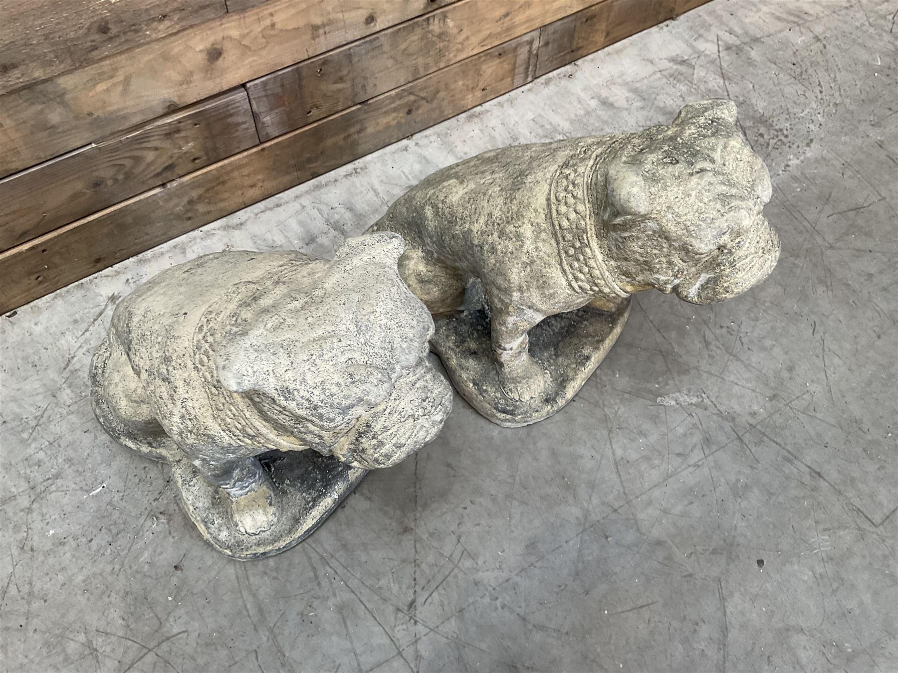 Pair of cast stone garden British bulldogs, on shaped plinths
