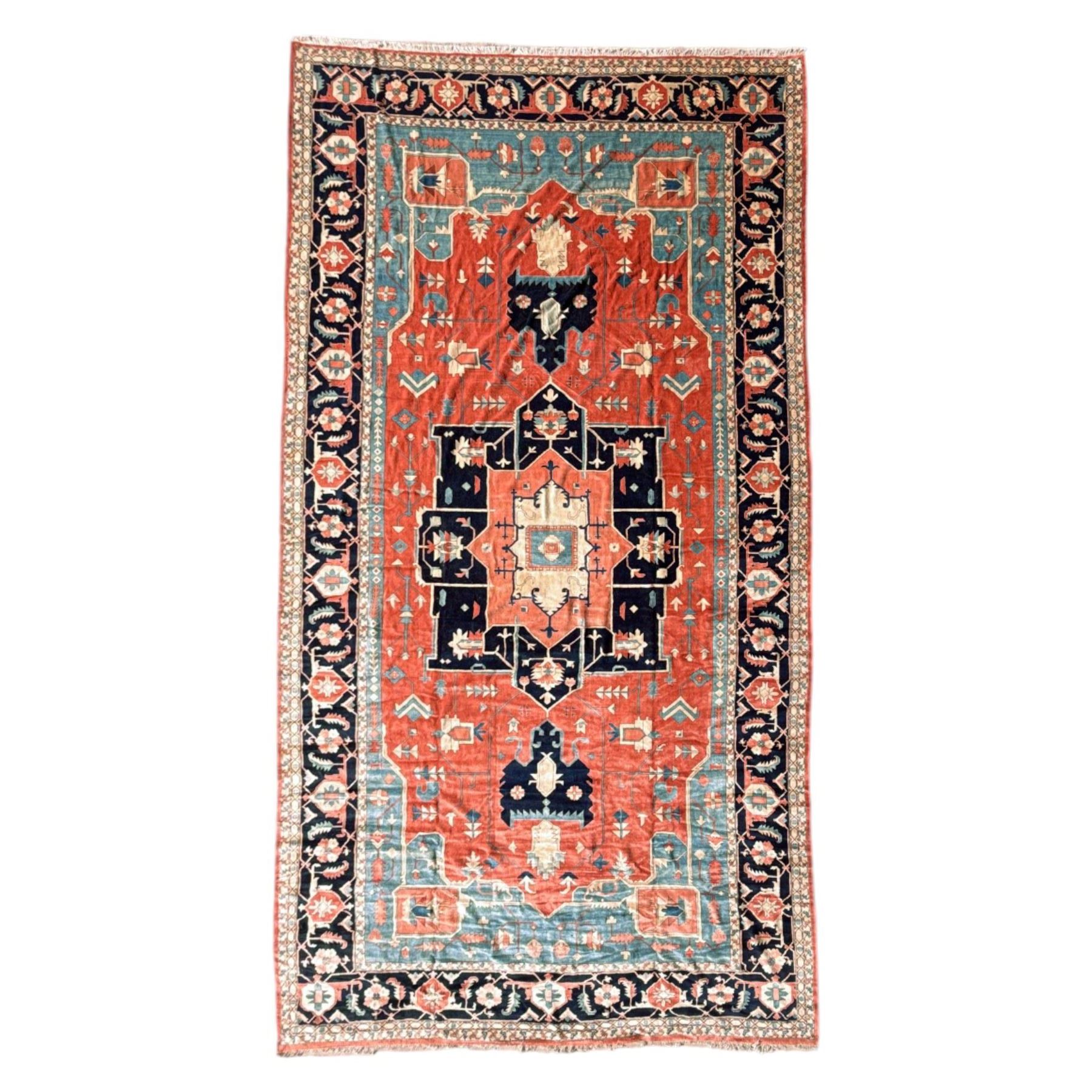 Exceptionally large Northwestern Persian Heriz, hand-knotted carpet, madder red field with a bold stepped medallion in indigo and ivory, and light blue spandrels within a dark indigo border of rosettes and angular vine motifs 




