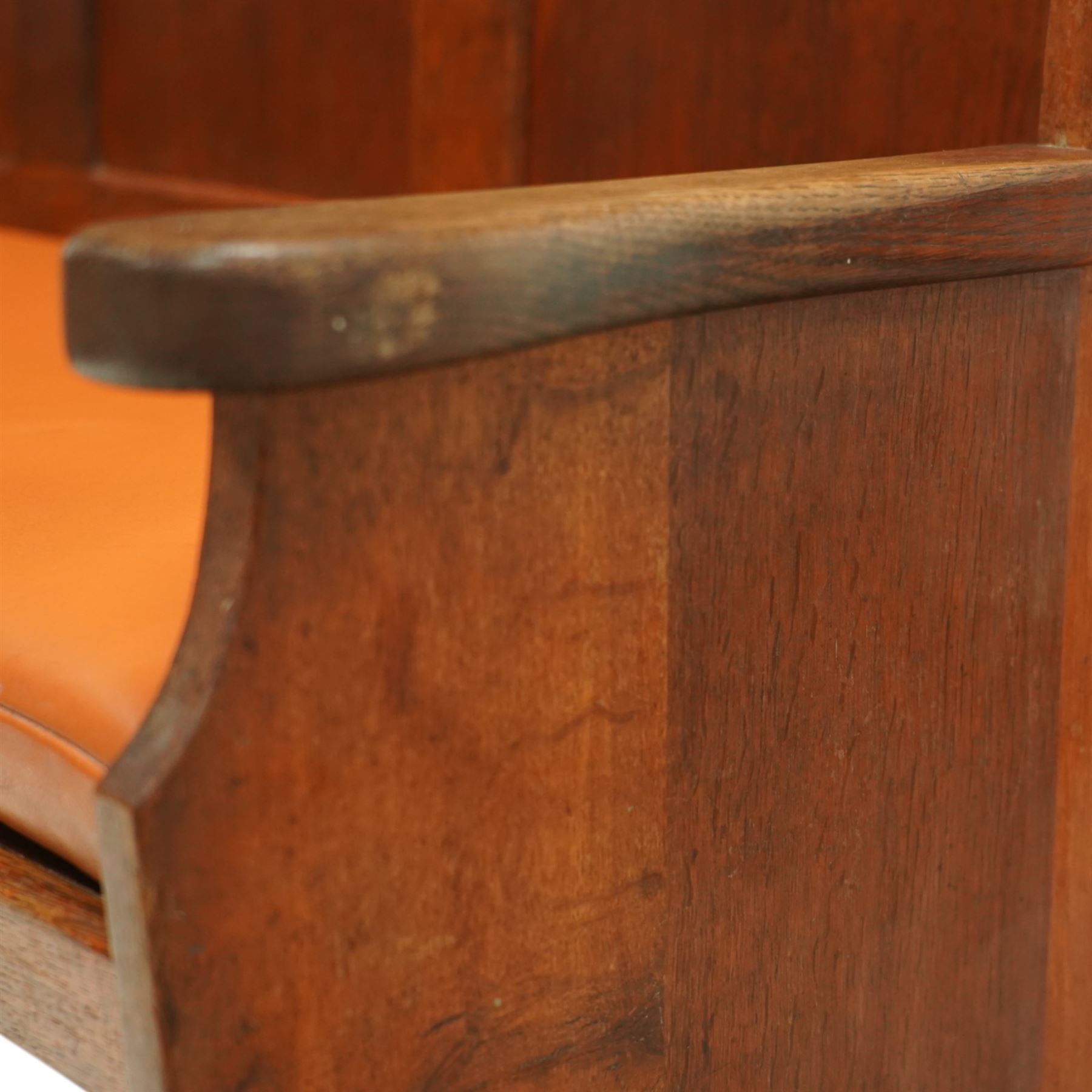 Sid Pollard of Thirsk – late 20th century adzed oak settle, tall panelled back with projecting top rail, shaped arms and tan upholstered drop-in seat, raised on chamfered end supports