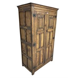 Mid-to-late 20th century oak double wardrobe, enclosed by panelled doors with linenfold decoration