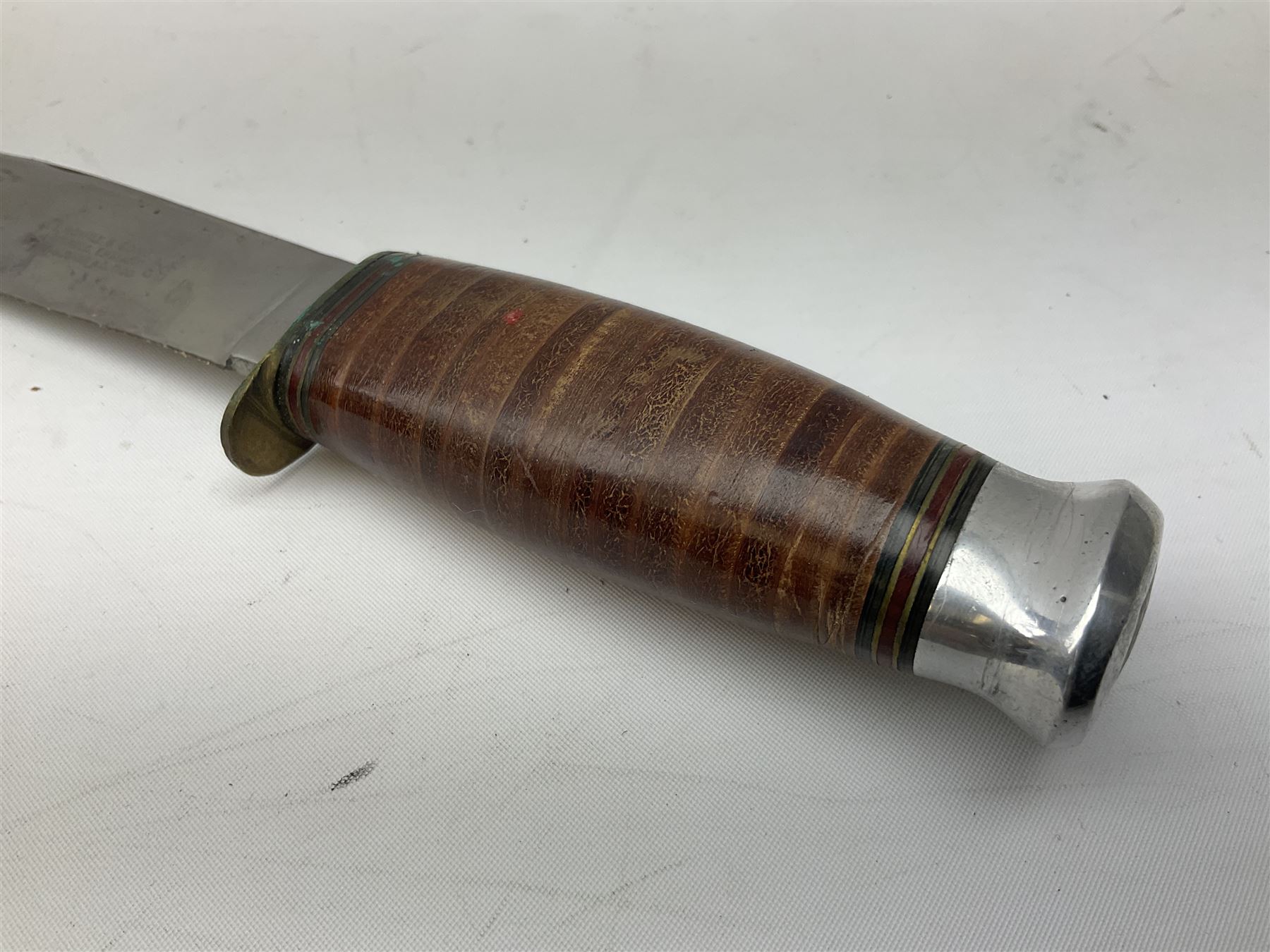 Graduated set of three Bowie knives by J. Nowill & Sons Sheffield England Est. AD1700, each with steel blade, brass cross-piece, stacked leather type grip and alloy pommel; largest blade 13cm and smallest 7.5cm; each in leather sheath (3)