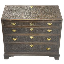  18th century heavily carved oak bureau, the fall front relief carved with three arches enclosing plants and flower head decoration, the interior fitted with pigeonholes, drawers and cupboard, four graduating cock-beaded drawers below, carved with lunettes and trailing foliage decoration, on bracket feet