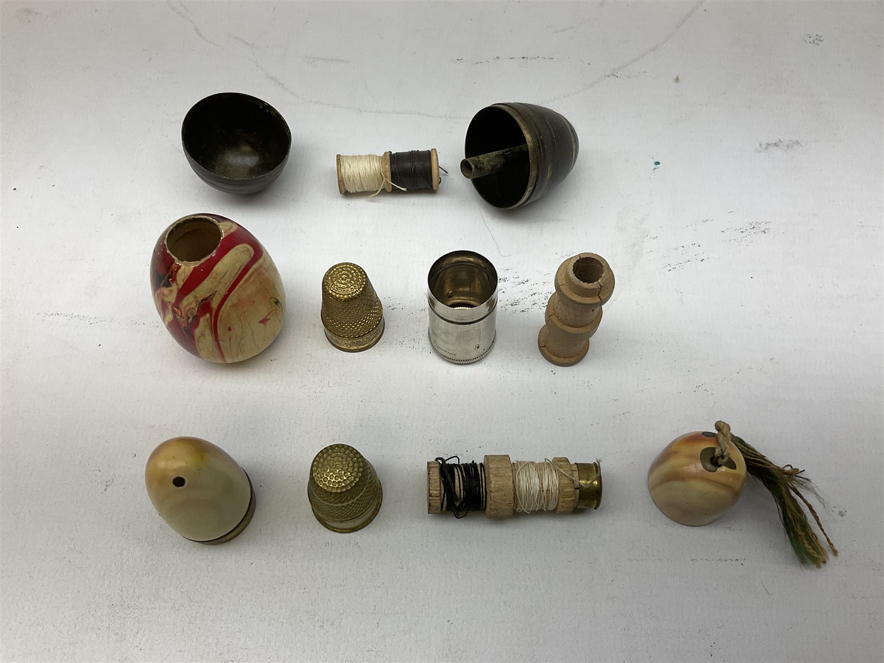 Collection of early 20th century and later thimble holders, to include a coquilla nut example, a floral decorated examples etc together with parquetry wooden tape measure 