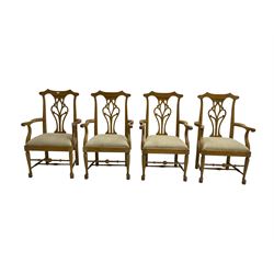 Set eight light oak Chippendale style carver dining chairs, shaped cresting rail with pierced and scrolled splat backs, upholstered seats with scrolling arm terminal, chamfered supports united by stretchers with pad feet