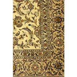 Central Persian Kashan carpet, ivory ground, field with an all-over design of scrolling palmettes and floral sprays in blue and terracotta within a beige ground and pale blue floral border
