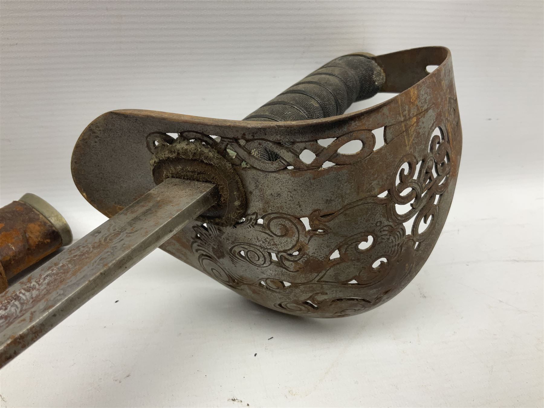 George V 1897 pattern Infantry officers sword, the 82cm single fullered blade with traces of etched detail and George V crown cipher, the ricasso marked Hawksworth Sheffield, pierced half basket hilt with George V cypher, wire-bound fish-skin grip with brass pommel and backstrap; in leather scabbard L102cm overall; together with two sectional gun cleaning rods; swagger stick made of leather strips etc