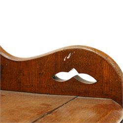 Late 19th century Gothic Revival carved oak hall chair or window seat, the swell-turned top rail centred by an arched carrying handle, over shaped open arms and solid plank seat, with pierced and carved scrolling foliate fretwork side panels and apron with applied central roundel, raised on shaped supports united by turned stretcher