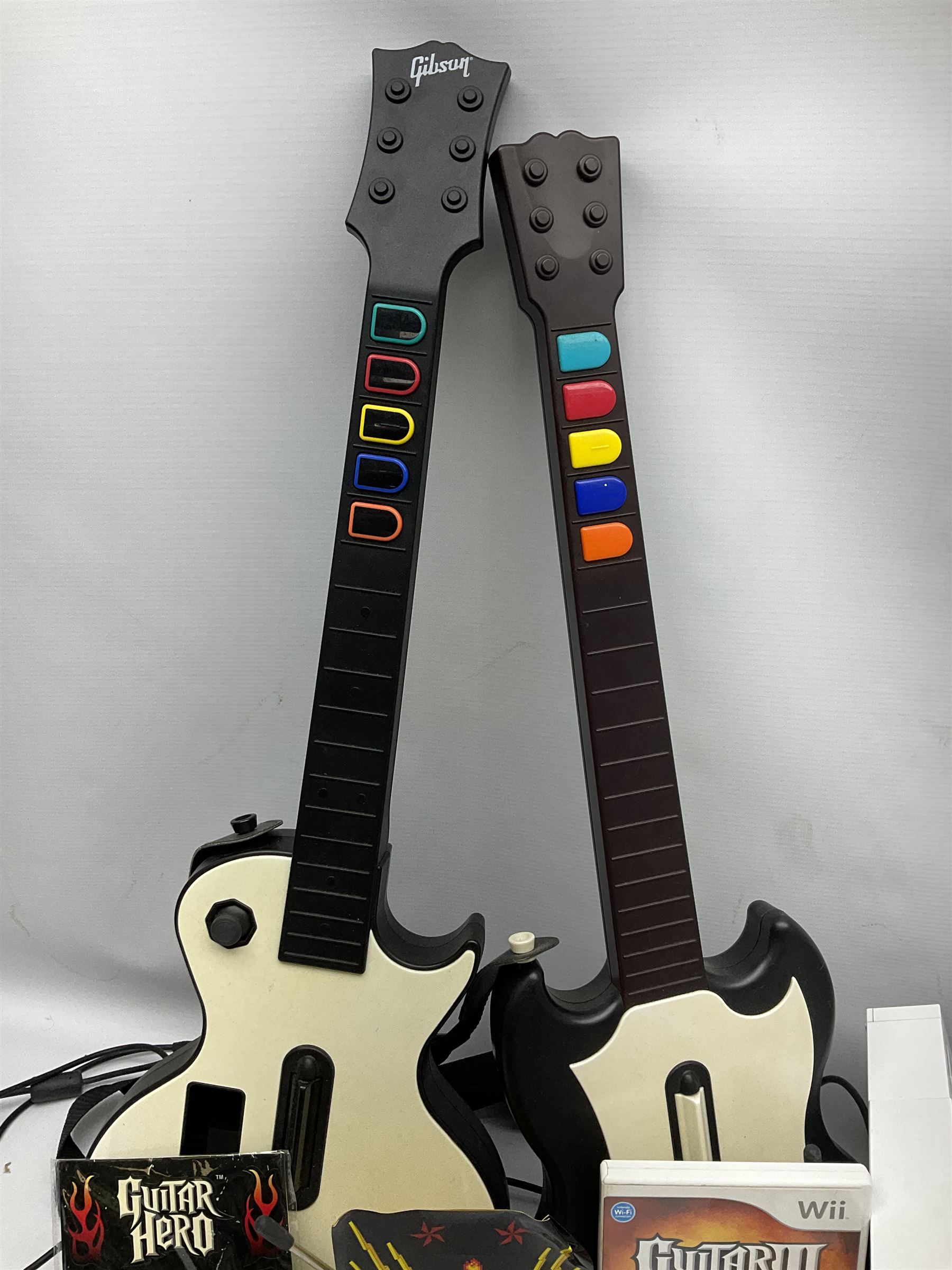 Nintendo Wii console, four controllers with cases and four nunchucks, Wii sensor bar, balance board and dance mat. Guitar hero wireless guitar for Wii and Redoctane wired guitar. Nintendo DS lite handheld gaming console, console and game cases and Guitar Hero Redoctane Guitar Grip. Selection of Nintendo Wii and Nintendo DS lite games to include Super Mario Galaxy, Guitar Hero, Wii Fit, Legend of Zelda games etc. Archos AV400 Series pocket video recorder with accessories, cradle and remote, in three boxes