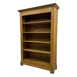 Contemporary French provincial design oak open bookcase, with projecting moulded cornice above a boarded back, fitted with four adjustable shelves, on bracketed plinth base