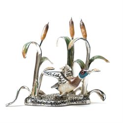 Silver and enamel model of a mallard taking flight from bulrushes and on a naturalistic ba...