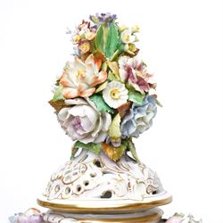 Pair of 19th century Potschappel porcelain two handled vases with covers and stands, painted with scenes of classical figures including Dionysus and Ariadne and with profusely applied flower heads on a scrolling field with gilt highlights H49cm (2)