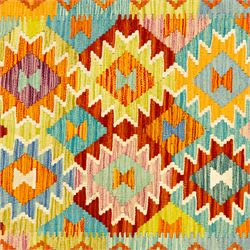 Afghan Chobi kilim flatweave runner with a repeating stepped diamond medallion design in live green, rust, teal, purple, and ivory, framed by chevron and geometric borders