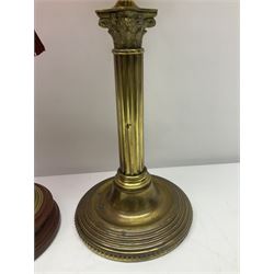 Victorian cast brass oil lamp, with fluted pink glass shade, together with two smaller brass oil lamps with pink shades and reservoirs and a pair of oil lamps, the bases modelled as putti, with pink glass reservoir  and frosted shades, tallest H70cm