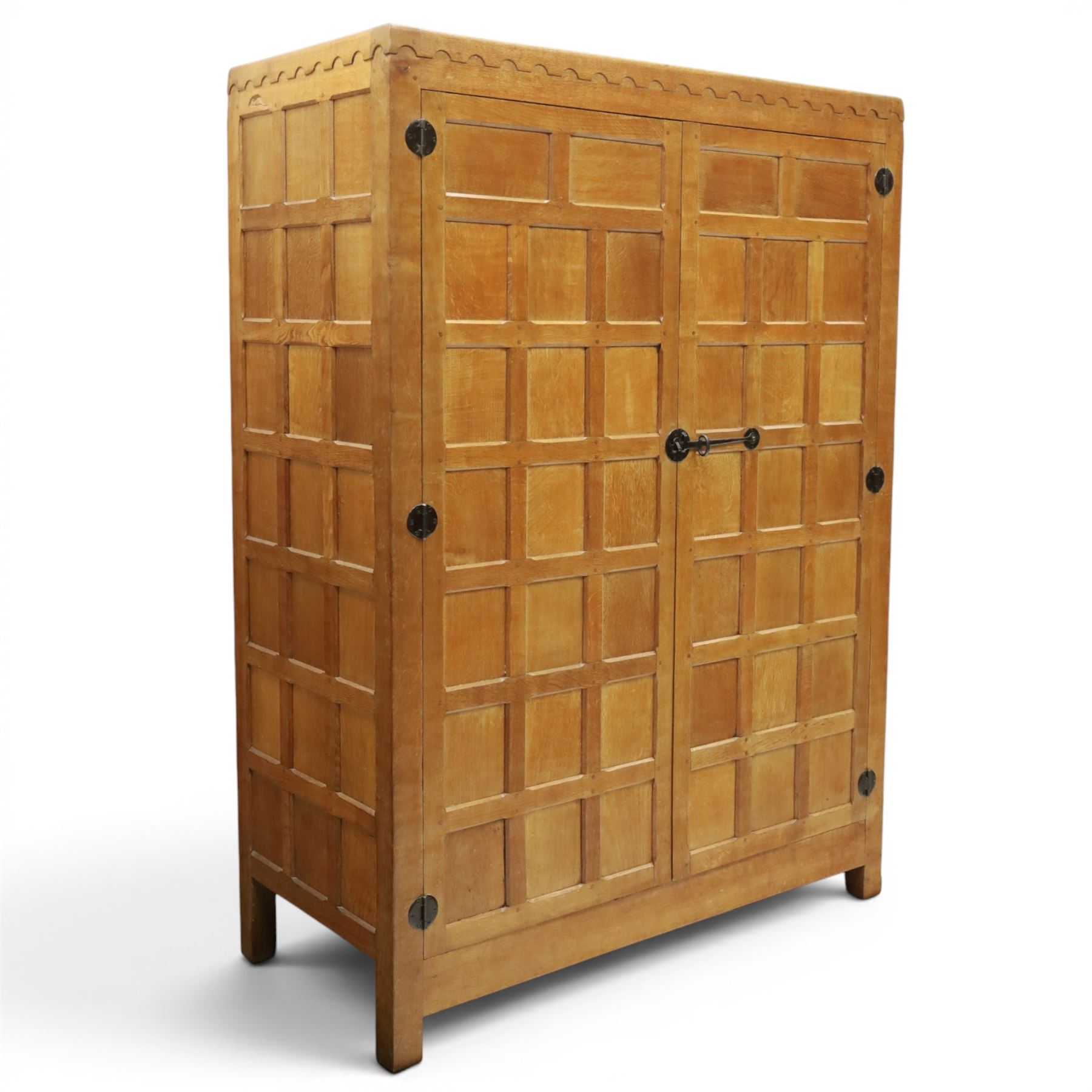 Mouseman - early-to-mid-20th century panelled and adzed double wardrobe, the arcade carved cresting rail over two panelled doors, with wrought metal hinges and latch, deep relief carved mouse signature, the interior fitted with hanging rail, by the workshop of Robert Thompson of Kilburn