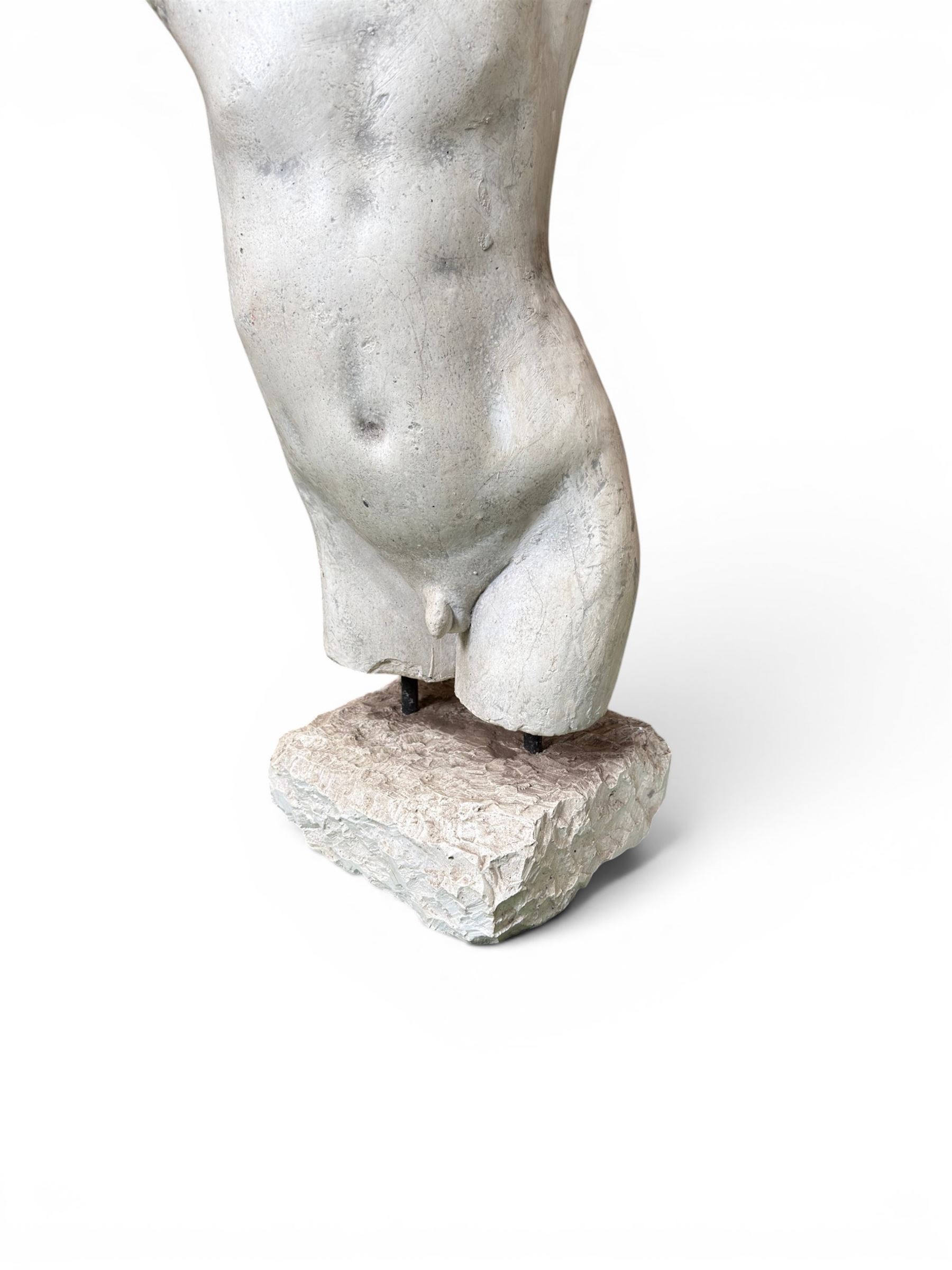 Early 20th century sculptured painted plaster figure of a boys torso, raised on 'stone' plinth