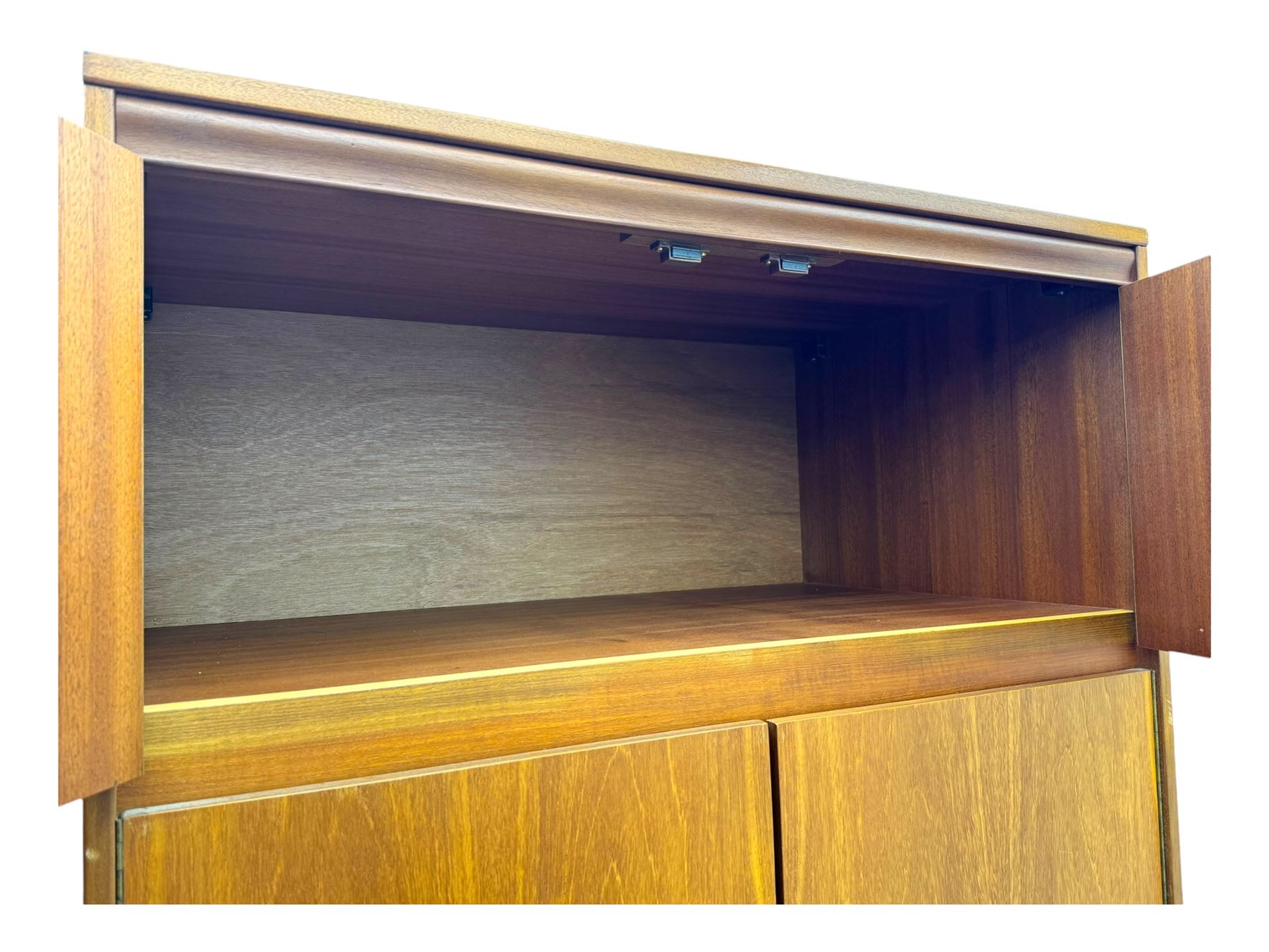 William Lawrence - mid-20th century teak double wardrobe, upper storage section over twin doors featuring recessed handles and contrasting horizontal panel, enclosing a hanging rail compartment, on plinth base with concealed castors